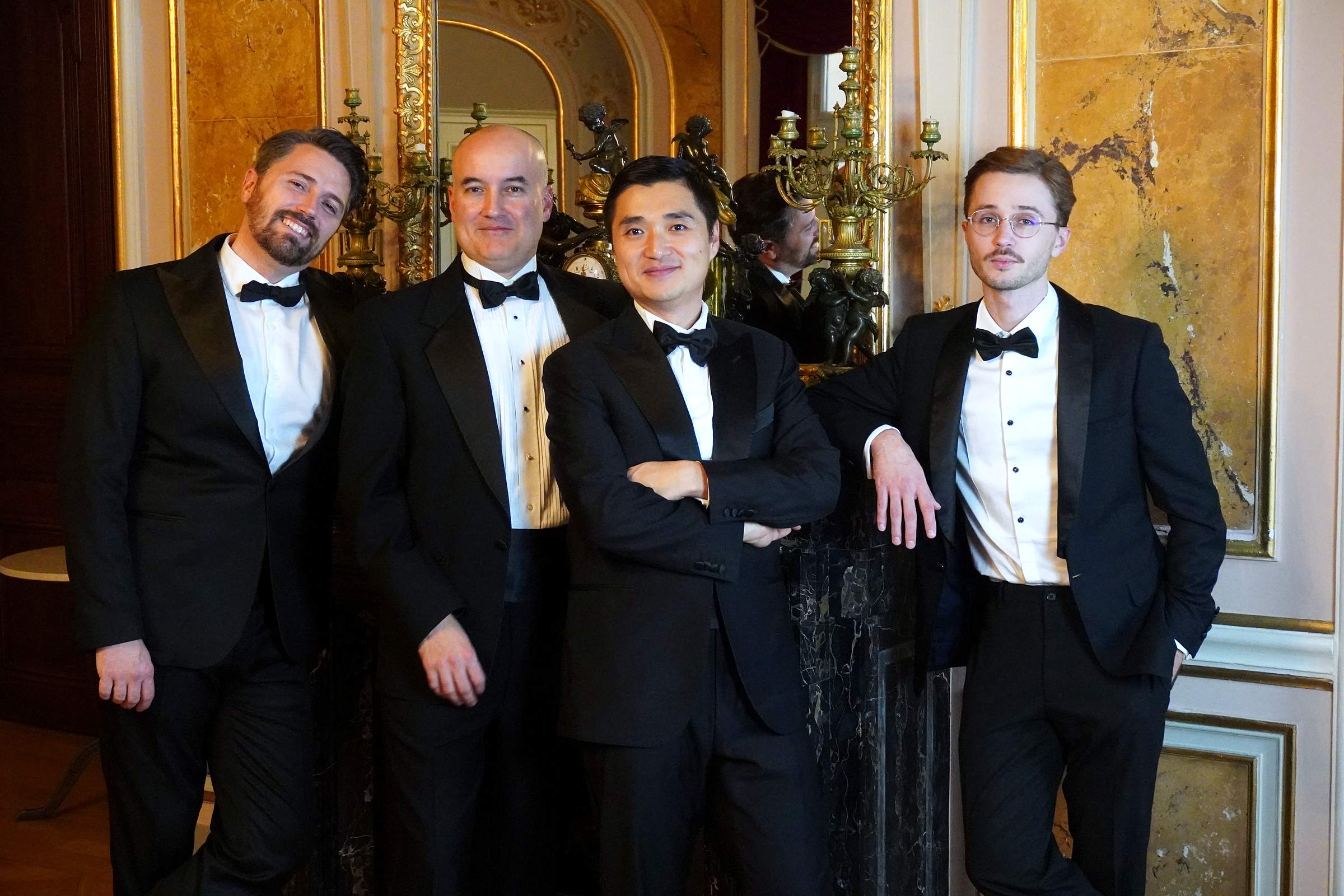 Die vier Sänger von I Barbieri Singers im Smoking, zusammen stehend in einem vergoldeten Saal